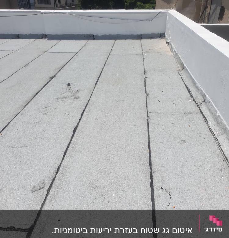 גג עם איטום ביטומני וסדקים שחורים